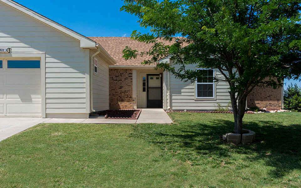 a white house with a tree in the front yard