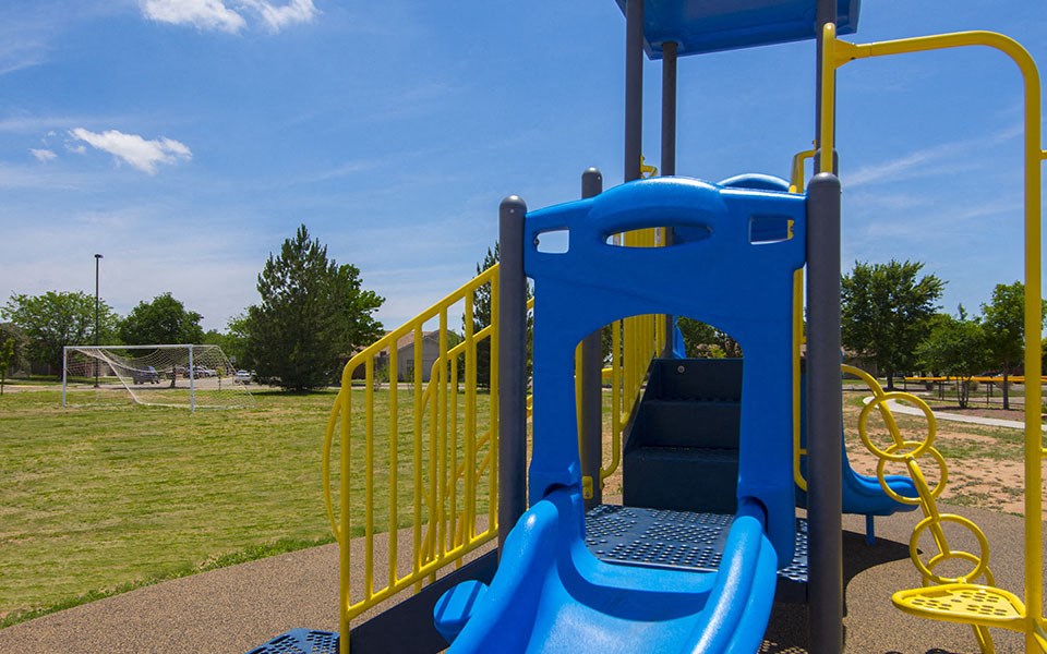 a playground at a park with a blue slide