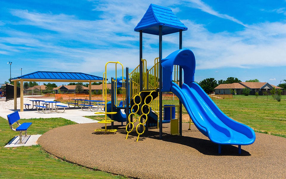 a playground with a blue slide at a park
