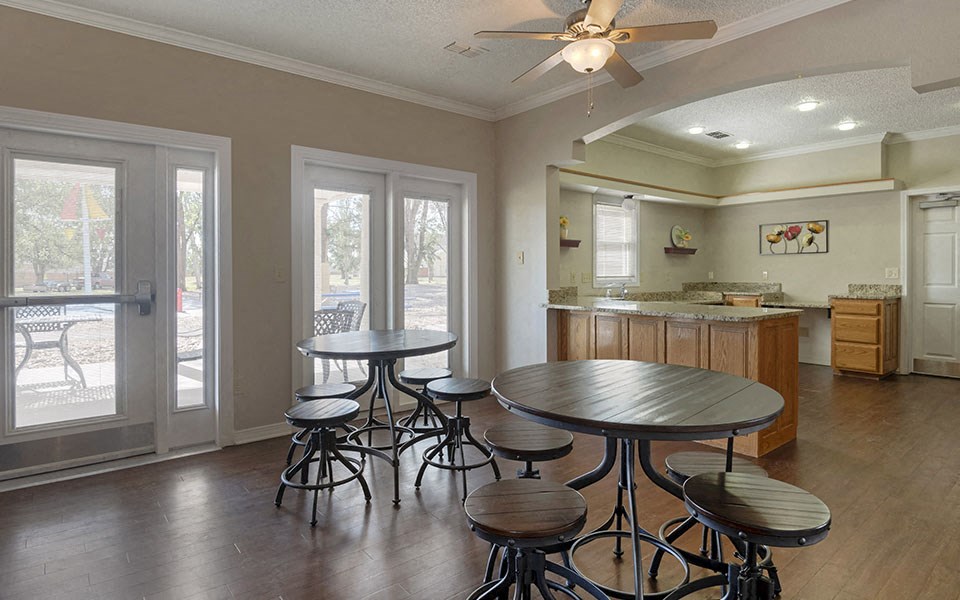 a dining room with a table and chairs in front of a kitchen