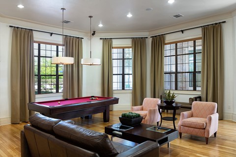 a living room with a pool table and couches