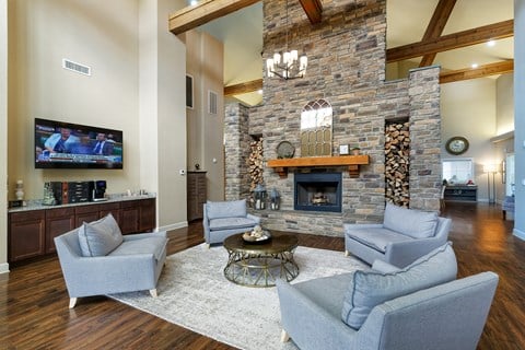 a living room with a large stone fireplace and couches