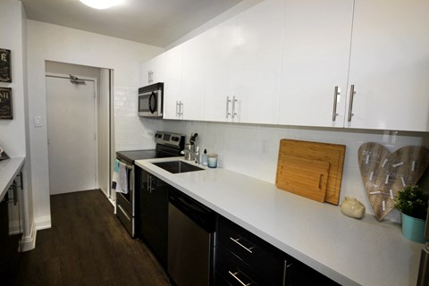 A kitchen with black appliances and white countertops.