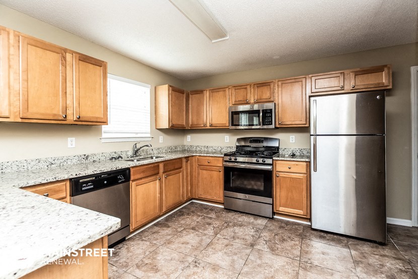 a kitchen with wooden cabinets and stainless steel appliances