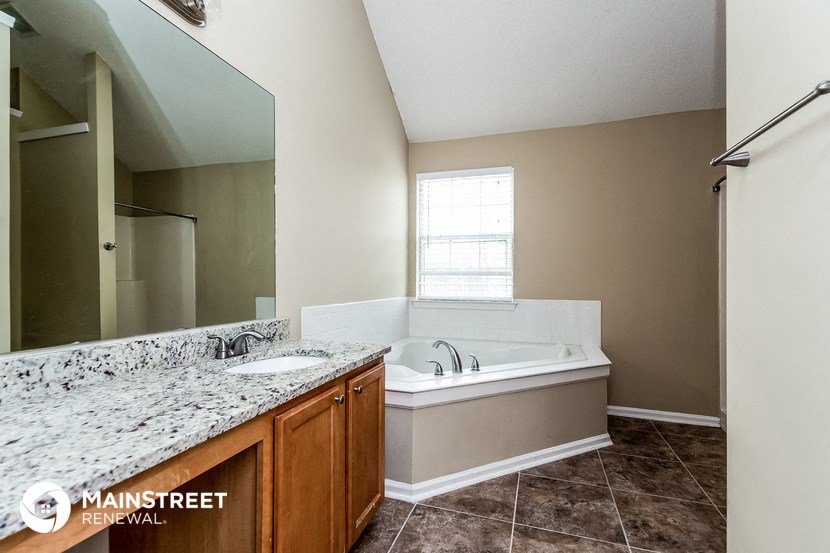a bathroom with a tub and a sink and a mirror