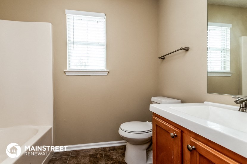 a bathroom with a toilet and a sink and a mirror
