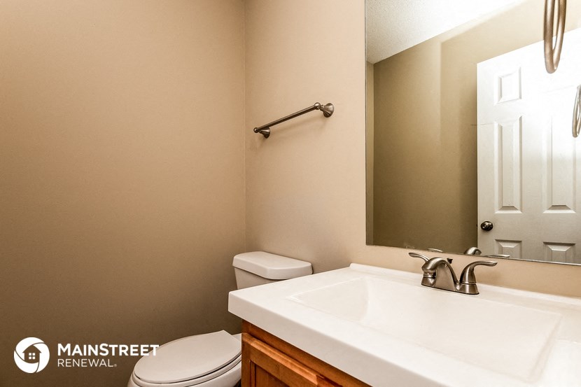 a bathroom with a sink toilet and a mirror
