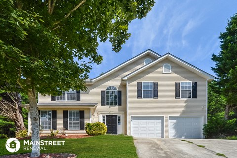 a tan house with a white garage door