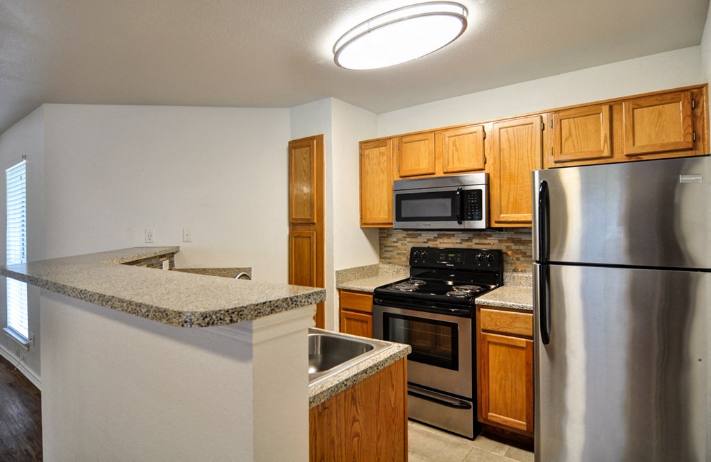 a kitchen with stainless steel appliances and granite counter tops