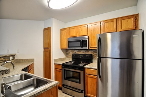 a kitchen with stainless steel appliances and wooden cabinets