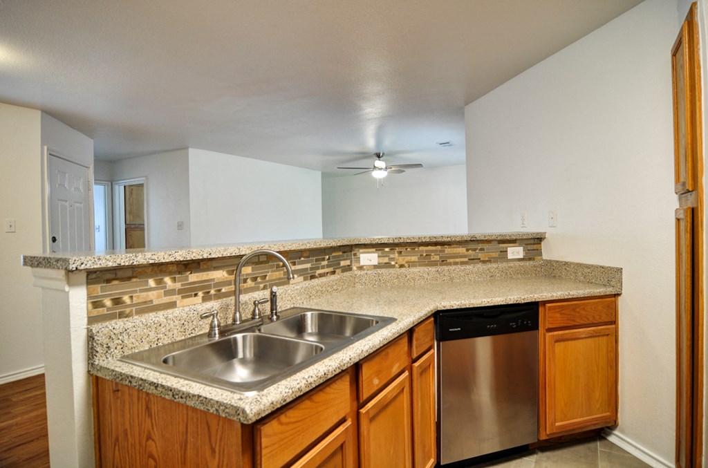 a kitchen with a granite counter top and a stainless steel sink