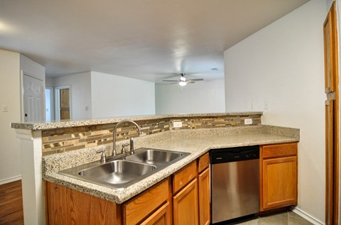 a kitchen with a granite counter top and a stainless steel sink