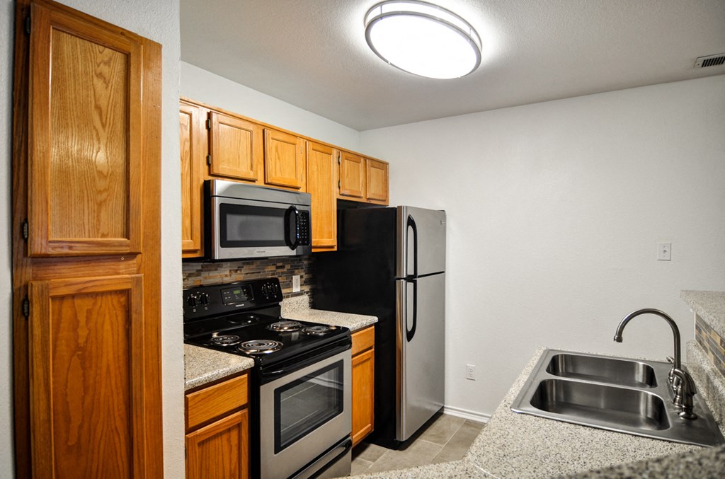 a kitchen with stainless steel appliances and wooden cabinets
