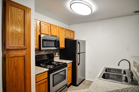 a kitchen with stainless steel appliances and wooden cabinets