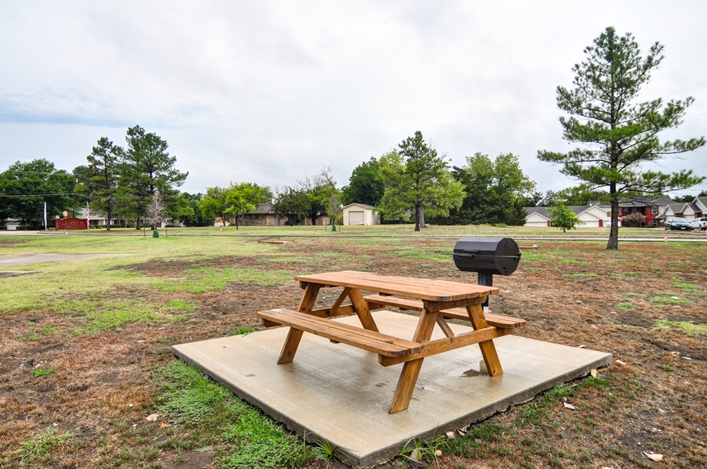 a picnic table with a grill on it in a park