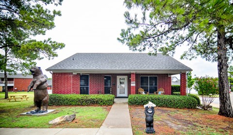 a statue of a bear in front of a house