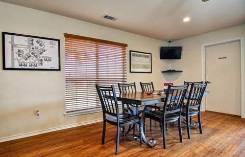 a dining room with a table and chairs and a tv