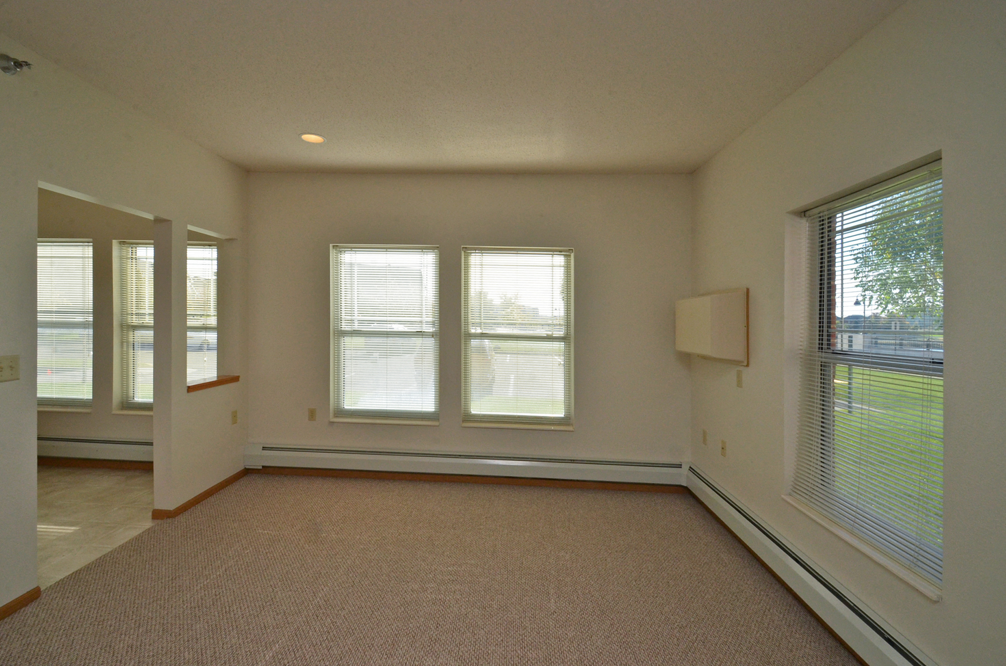 the living room of an empty house with windows