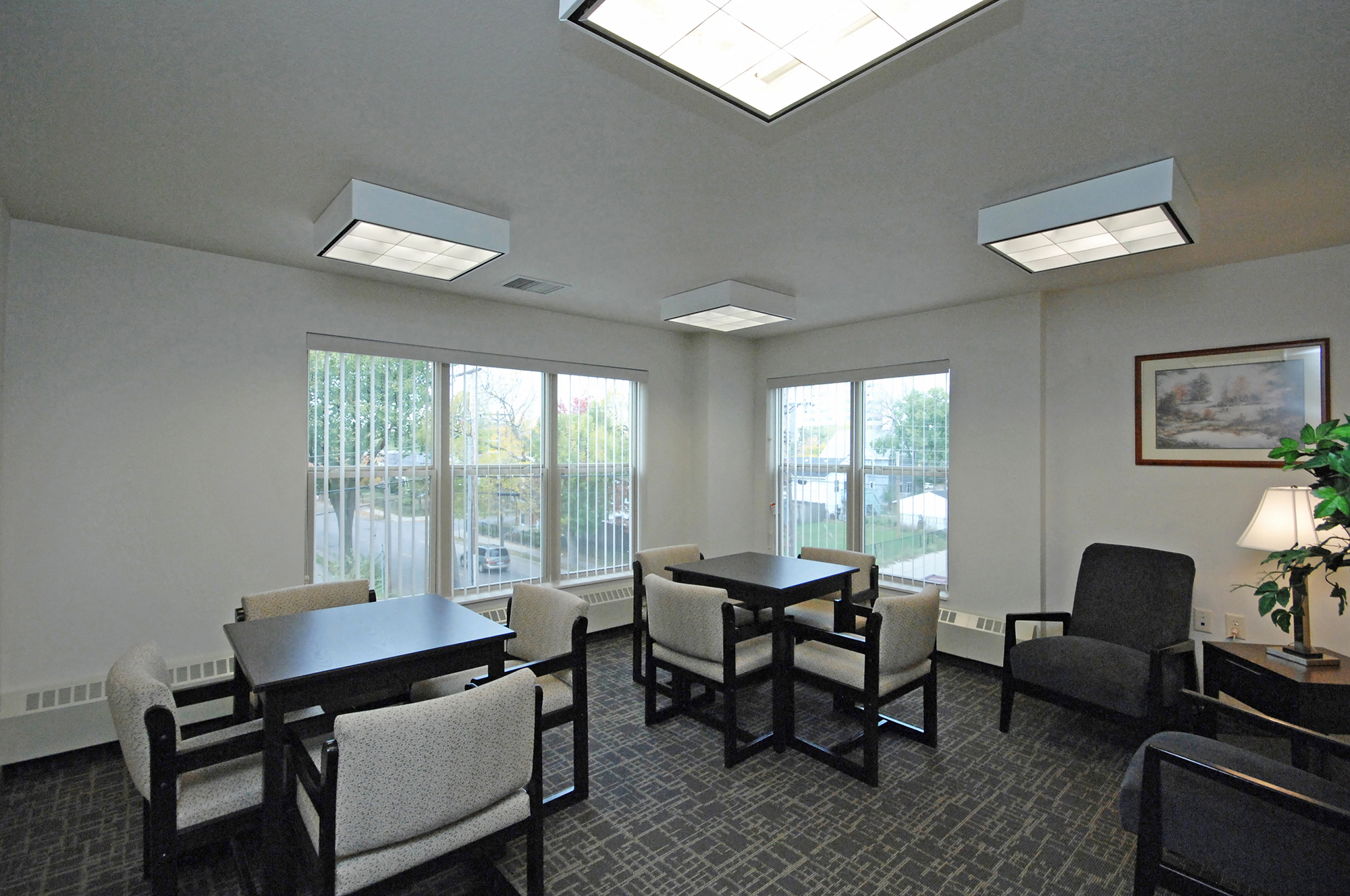 a dining room with tables and chairs and large windows