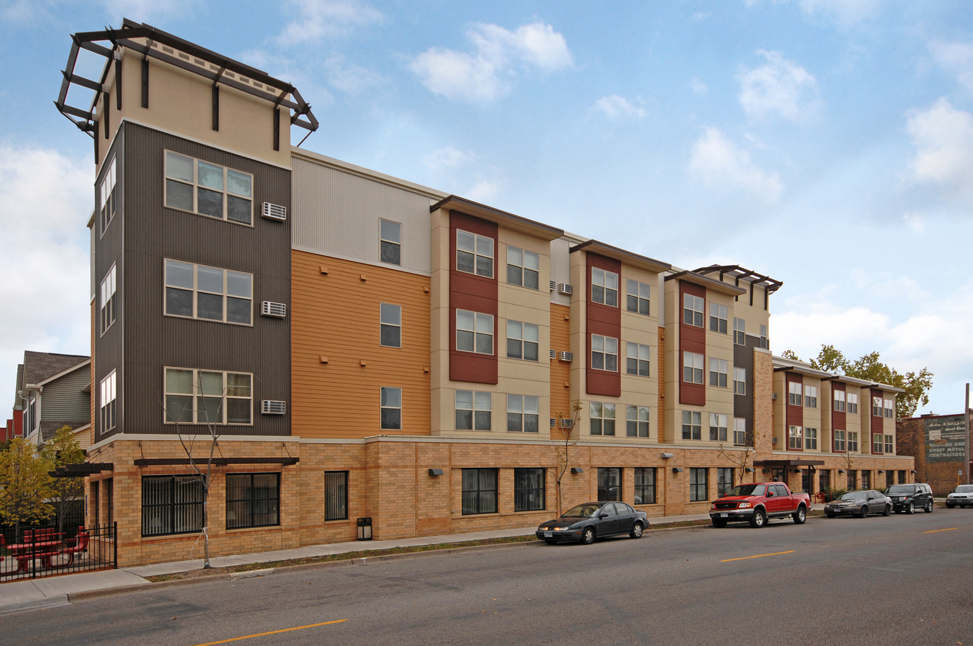 an apartment building on a city street with parked cars