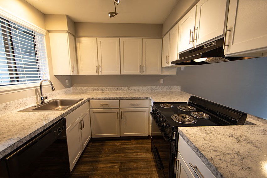 a kitchen with marble counter tops and white cabinets