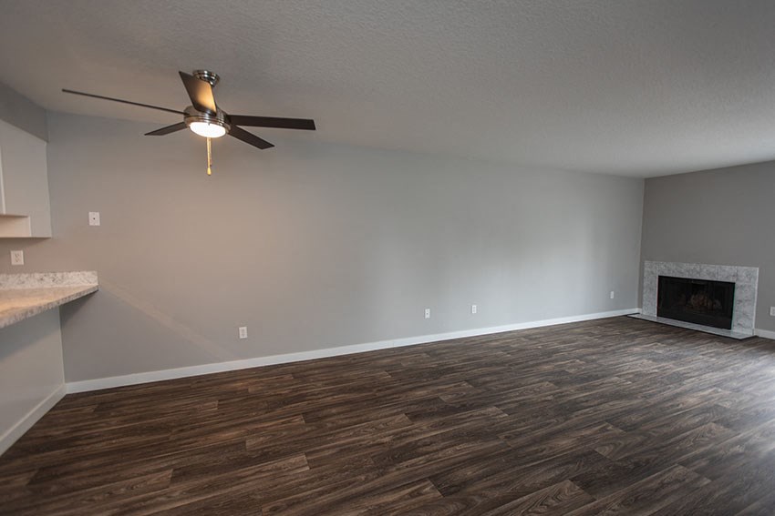 a living room with a ceiling fan and a fireplace