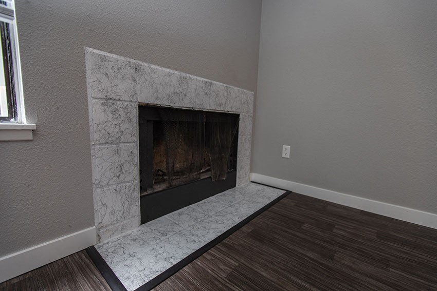 a living room with a fireplace and a wooden floor