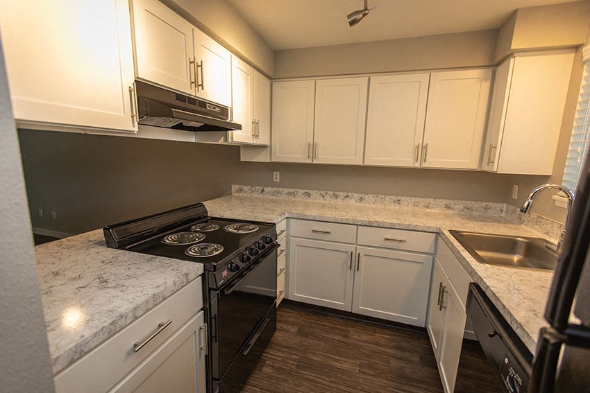 a kitchen with white cabinets and a stove and a sink