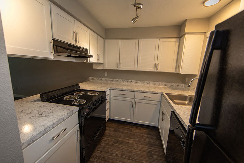 a kitchen with white cabinets and a black stove