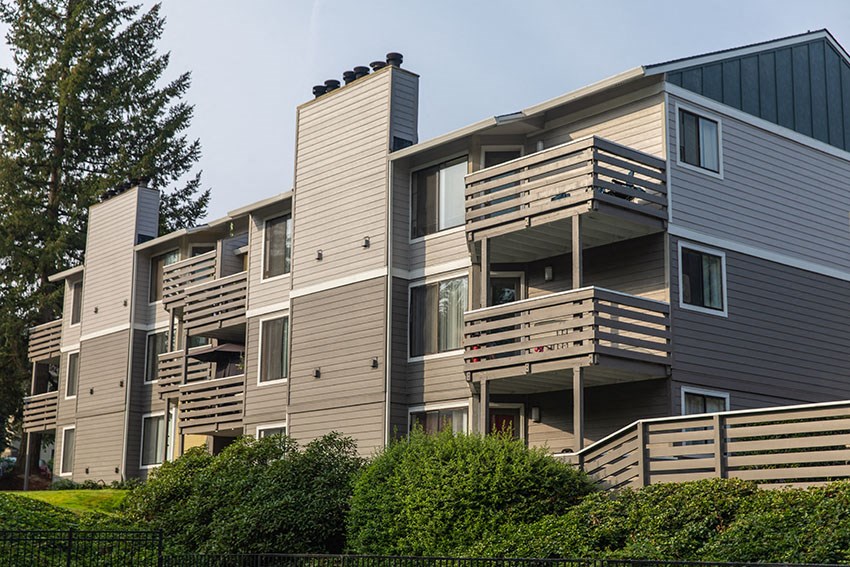 a row of apartment buildings with balconies and trees