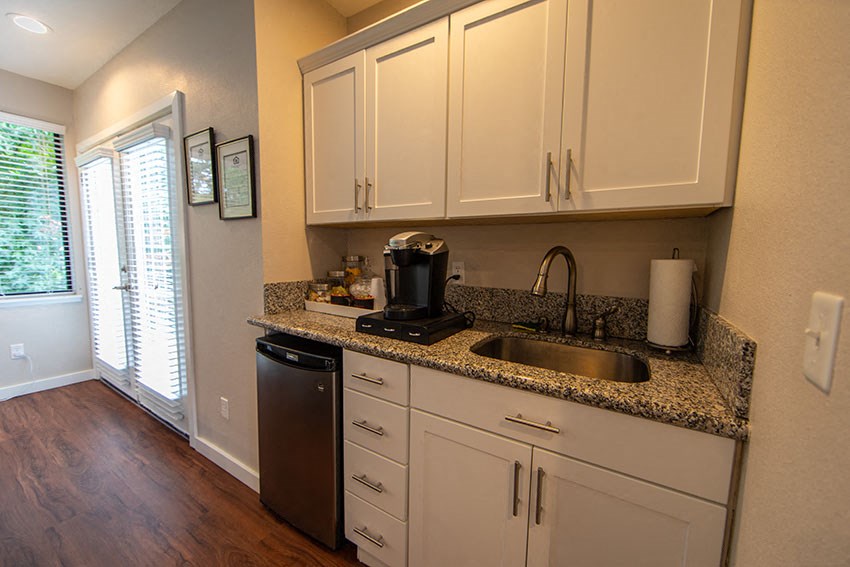 a kitchen with white cabinets and a sink and a window