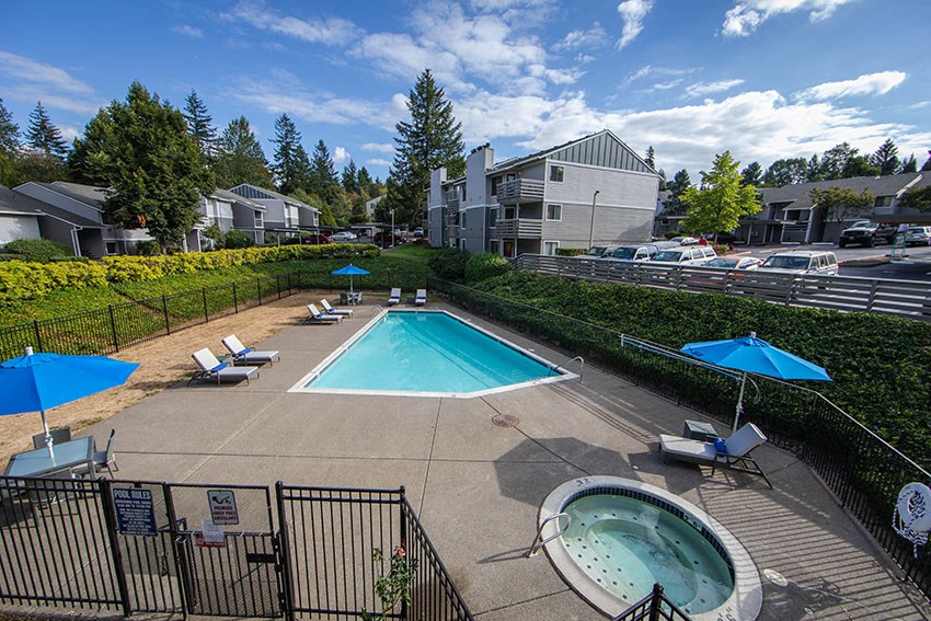 a pool with chairs and umbrellas next to a pool