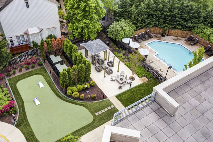 a backyard with a pool and a patio with tables and chairs