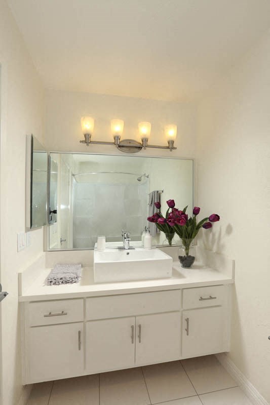 a white bathroom with a sink and a mirror