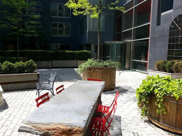 a courtyard with a table and chairs in front of a building