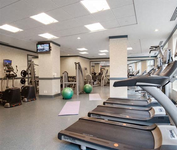 A gym with treadmills, exercise balls, and other equipment.