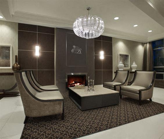 A modern living room with a fireplace and a chandelier.