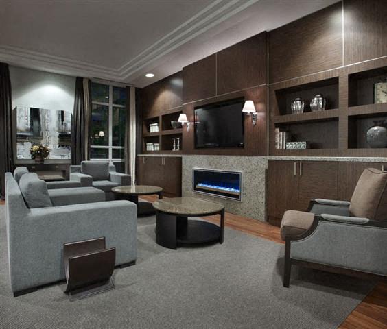 A modern living room with a grey sofa set, a coffee table, and a television.