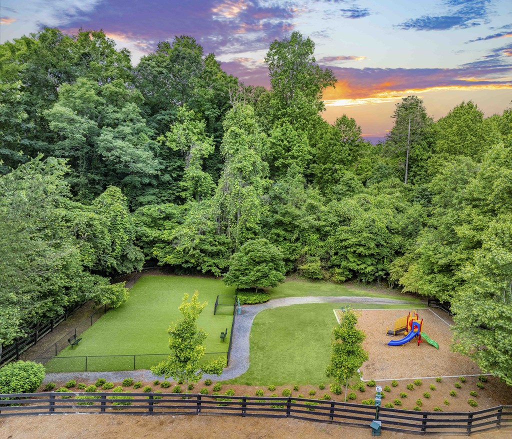 A backyard with a playground and a fence.