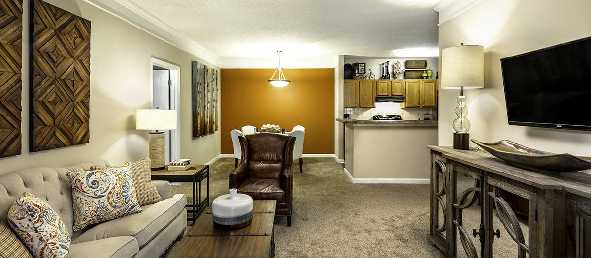 a living room with a couch and a chair and a kitchen