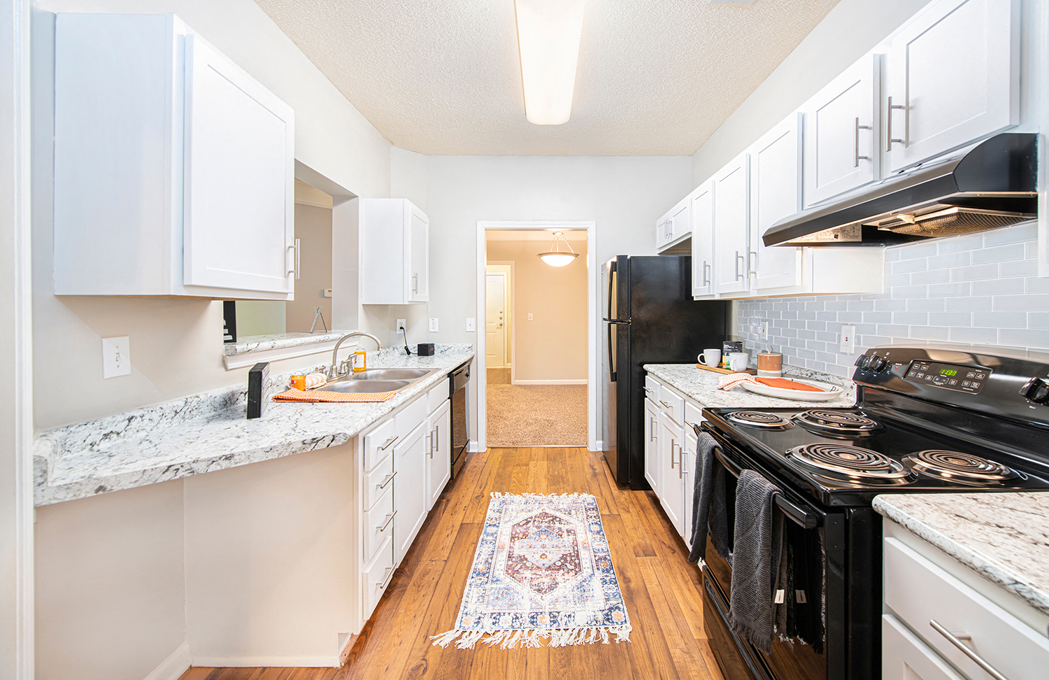 a renovated kitchen with white cabinets and black appliances