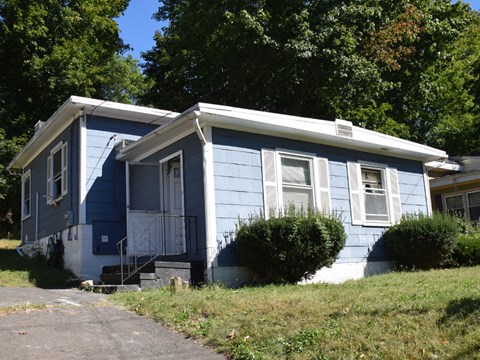 A blue house with white trim and a white door.