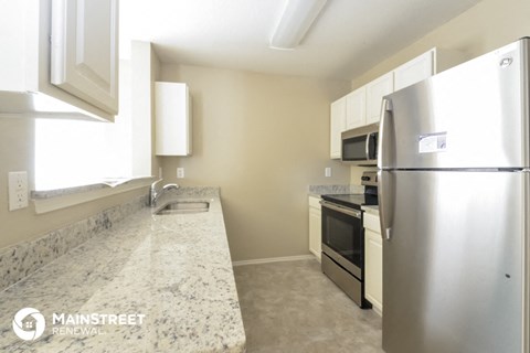 a kitchen with granite counter tops and stainless steel appliances