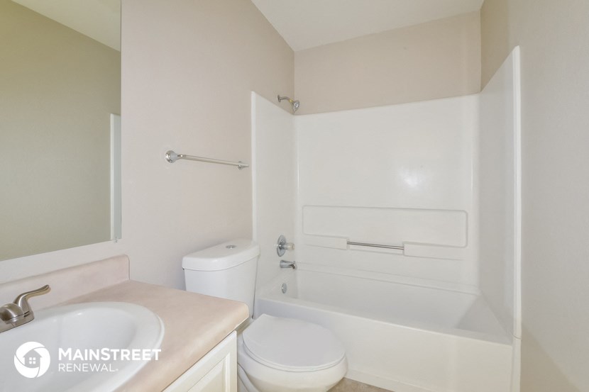 a bathroom with a toilet and a tub and a sink