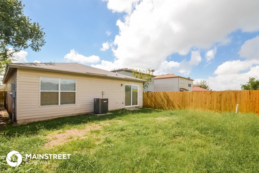the backyard of a house with a yard and a fence