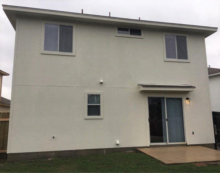 the front of a white house with a door