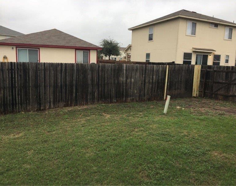 a backyard with a fence and a house