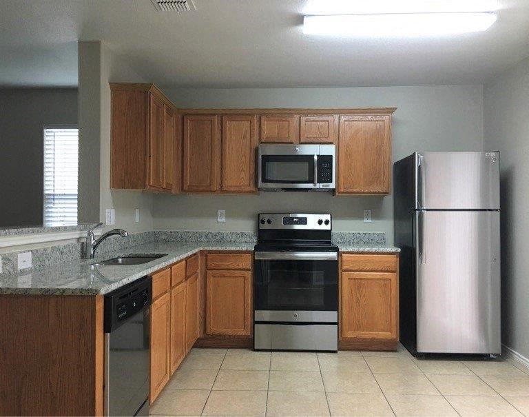 a kitchen with stainless steel appliances and wooden cabinets