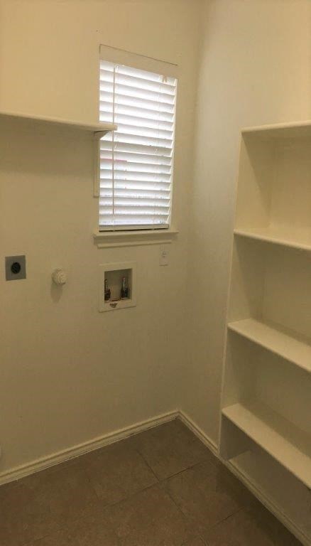 an empty room with shelves and a window