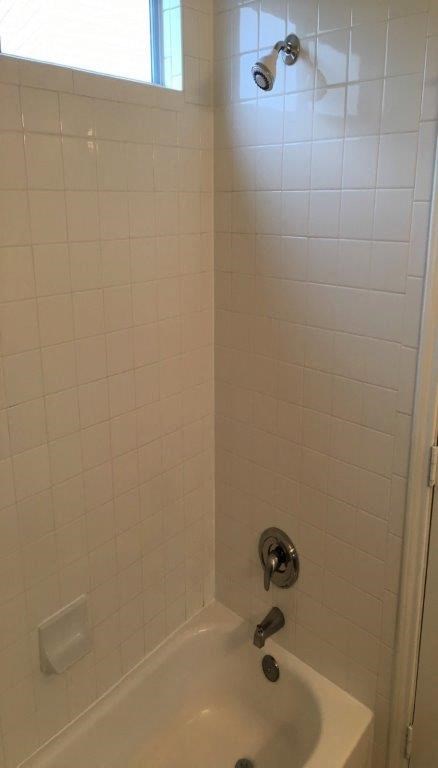 a white bathroom with a shower and a sink